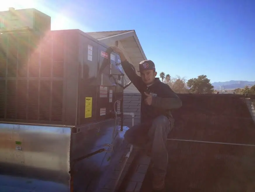 HVAC technician performing AC Tune-Up on a rooftop unit in Chula Vista